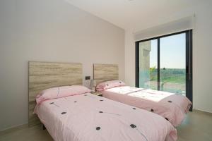 two beds in a room with a large window at Fruta in La Mata +33 photos