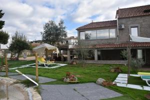a house with a yard with a swing at DIGNUS HOUSE in Folhadosa