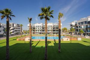 a group of palm trees in front of a building at Fruta in La Mata
