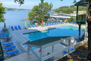 una piscina con sillas y una mesa junto al agua en Pool Access Waterfront Lake Ozark Condo with Patio, en Lake Ozark