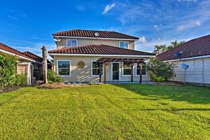 a white house with a grass yard at Walk to Ocean Lakefront Dickinson Stucco House! in Dickinson