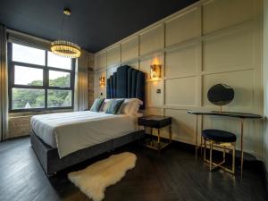 um quarto com uma cama grande, uma mesa e cadeiras em Bowers Mill Aparthotel em Barkisland