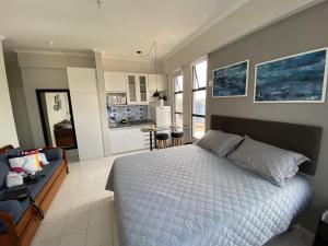 1 dormitorio con 1 cama grande y cocina en Apartamento Studio - Novíssimo e Aconchegante em Caxambu MG, en Caxambu