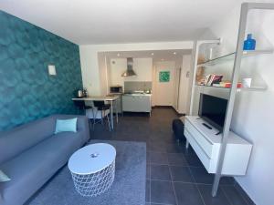a living room with a blue couch and a table at Les Suites du Port in Le Bourget-du-Lac