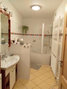 ein Badezimmer mit einem Waschbecken, einer Dusche und einer Badewanne in der Unterkunft PENZION VLASTA in Zlín