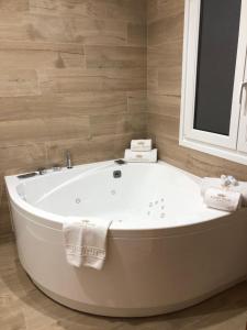 a white bath tub in a bathroom with a mirror at Luxury Apartment with Jacuzzi in Santiago de Compostela