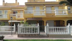 una recinzione bianca di fronte a un edificio giallo di Holiday Rental, El Poblet, El Campello, Alicante ad Alicante