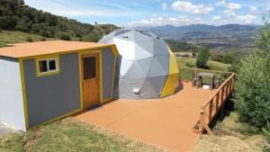 a building with a tent on top of a field at Glamping Altos de Quiluva in Suesca