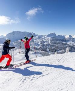 two people on skis on a snow covered mountain at Terezia-Appartements Nassfeld in Hermagor