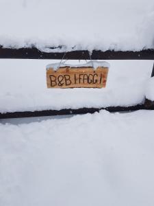 un signo que lee la bibliografía en una acera cubierta de nieve en B&B I FAGGI, en Lavarone