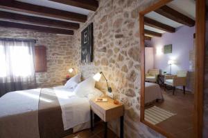 a bedroom with a bed and a stone wall at Casa rural restaurante Mas Del Rei in Calaceite