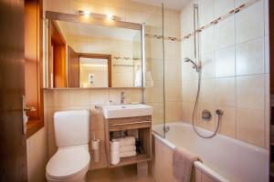 a bathroom with a toilet and a sink and a tub at Pension Inge in Sankt Anton am Arlberg +15 photos