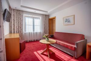 a living room with a red couch and a table at Pension Inge in Sankt Anton am Arlberg