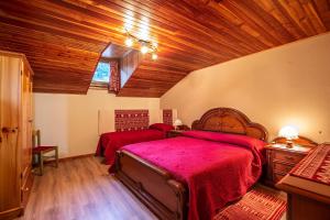 una camera con 2 letti e un soffitto in legno di L'Atelier du Temps - HERBETET Appartement a Cogne