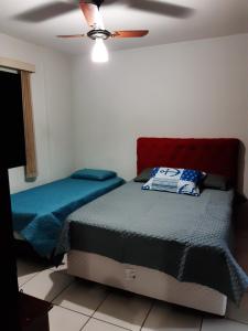 a bedroom with two beds and a ceiling fan at Alto Padrão com 94 mtrs - Frente Mar - sacada com Vista Mar in Praia Grande