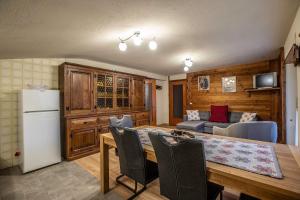 a kitchen and dining room with a table and a refrigerator at L'Atelier du Temps - HERBETET Appartement in Cogne