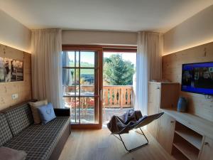 a living room with a couch and a balcony at Trafunshof natural living in Vols am Schlern