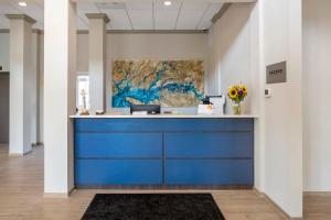 una recepción azul en un vestíbulo con una pintura en The Inn at Leonardtown, Ascend Hotel Collection, en Leonardtown