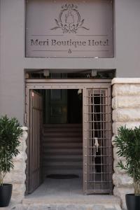 Meri Boutique Hotel في كورتشي: بوابة تؤدي الى باب الفندق الأمامي