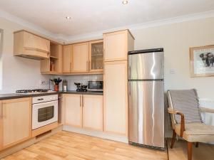uma cozinha com armários de madeira e um frigorífico de aço inoxidável em 19 Quayside Walk em Southampton