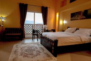 八田Hatta Guest House的一间带大床和大窗户的卧室