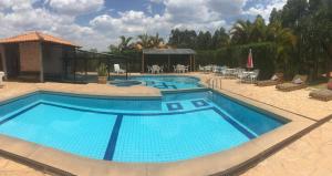 a large pool with blue water in a resort at Hotel Fazenda da Lagoa in Queluzita
