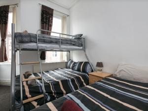 1 dormitorio con 2 literas y ventana en Short Term Shared R&R In Chorlton en Mánchester