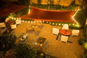 een patio met stoelen, een tafel en verlichting bij Borgo Vergini Garden B&B in Napels