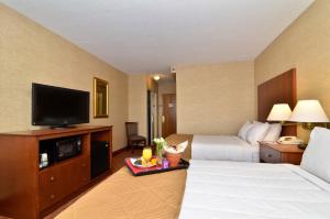 a hotel room with a bed and a flat screen tv at Clarion Hotel Airport Portland in Portland