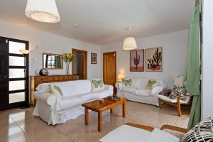 ein Wohnzimmer mit zwei weißen Sofas und einem Tisch in der Unterkunft Villa Mariposa in Playa Blanca + 14 Fotos