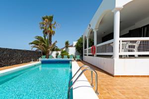 ein Schwimmbad vor einem Gebäude in der Unterkunft Villa Mariposa in Playa Blanca
