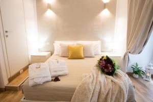 a bedroom with a bed with towels and flowers on it at Chroma Italy - Chroma Octho in Rome