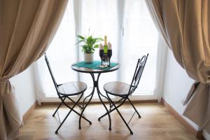 a table and two chairs in a room with a window at Chroma Italy - Chroma Octho in Rome