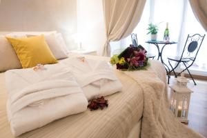 a bed with white towels and flowers on it at Chroma Italy - Chroma Octho in Rome
