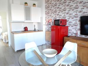 a kitchen with a red refrigerator and a table and chairs at Vistas Melenara by CanariApartment - Beachfront Apartments with Balcony and Fast WiFi in Telde