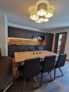 eine Küche mit einem Holztisch und schwarzen Stühlen in der Unterkunft Apart Grafspitz in Ischgl