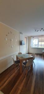 a dining room with a table and chairs and a clock at Apartament w Suwałkach in Suwałki