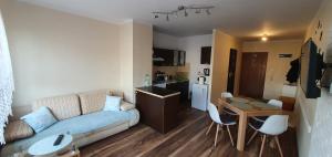 ein Wohnzimmer mit einem Sofa und einem Tisch sowie eine Küche in der Unterkunft Apartament w Suwałkach in Suwałki