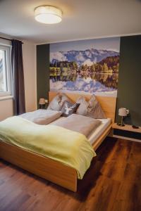 - une chambre avec un grand lit orné d'une peinture murale dans l'établissement Aberle Apartments, à Rossleithen