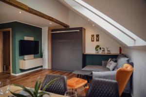 a living room with a couch and a tv at Aberle Apartments in Rossleithen