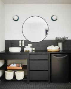 a bathroom with a black vanity with a mirror at Somewhere Inn Calabogie in Calabogie