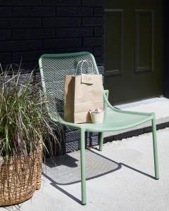 a shopping bag sitting on a green chair next to a door at Somewhere Inn Calabogie in Calabogie