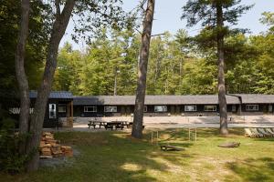 a building with a group of picnic tables and trees at Somewhere Inn Calabogie Boutique Hotel in Calabogie