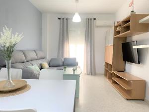 een woonkamer met een bank en een tafel bij Apartamento entero a 10 minutos en coche de Sevilla Centro in Camas