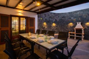 a dining room with a table and chairs and a fireplace at Villa Amana 5 star luxury resort for 10 people in Playa Blanca in Playa Blanca