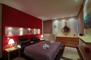 czerwona sypialnia z łóżkiem i wanną w obiekcie Villa Arcadia w mieście Vlakhérna