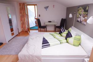 ein großes weißes Bett in einem Zimmer mit einem Tisch in der Unterkunft Frühstückspension Mayer-Schiller in Bernried