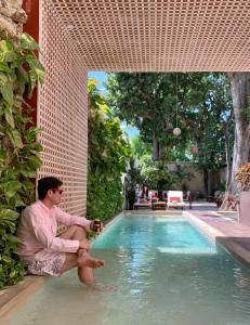 a woman sitting in the water next to a swimming pool at Casa Italia Luxury Guest House - Adults Only in M&eacute;rida
