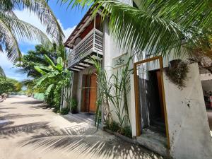 a house with a palm tree next to a street at Dhooni Finolhu Guesthouse in Maalhos