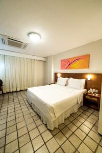 a bedroom with a large white bed in a room at Hotel Praia Centro in Fortaleza